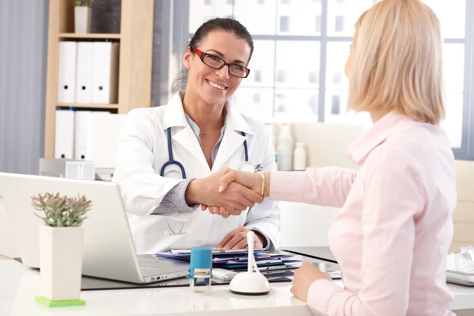 Practitioner conducting a functional medicine health consultation — reviewing patient history and test results