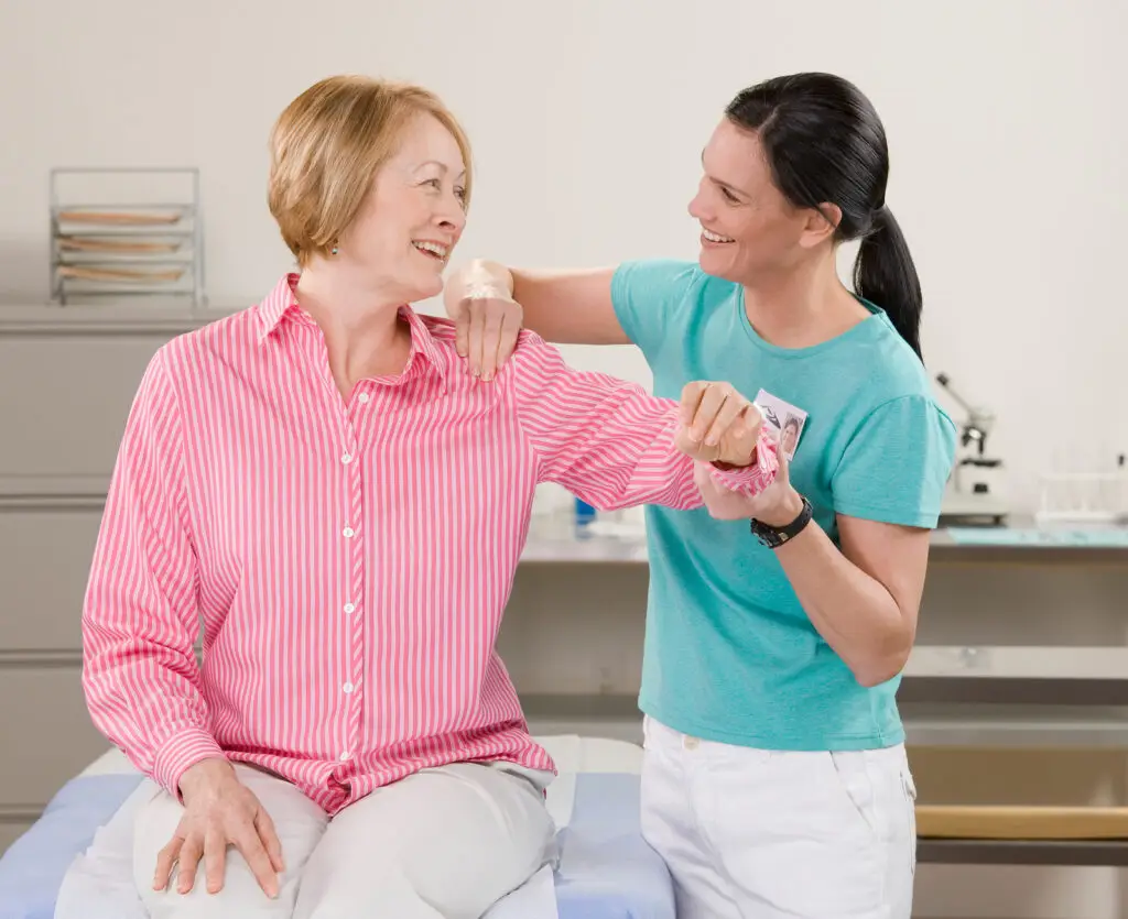 Practitioner guiding a patient through shoulder rehabilitation exercise