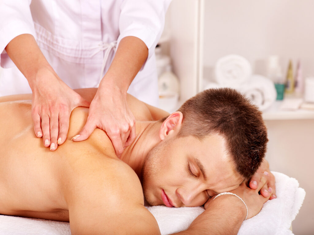 Practitioner treating the upper back and shoulders of a male client at Premier Wellness