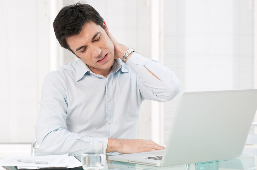 Office worker with neck pain from an incorrectly set up workstation