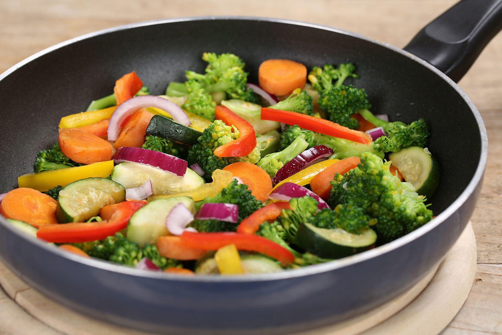 Broccoli, capsicum, carrot and red onion cooking in a frying pan