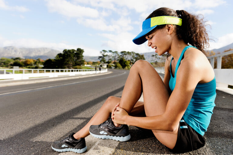 Runner holding a sprained ankle after a running injury