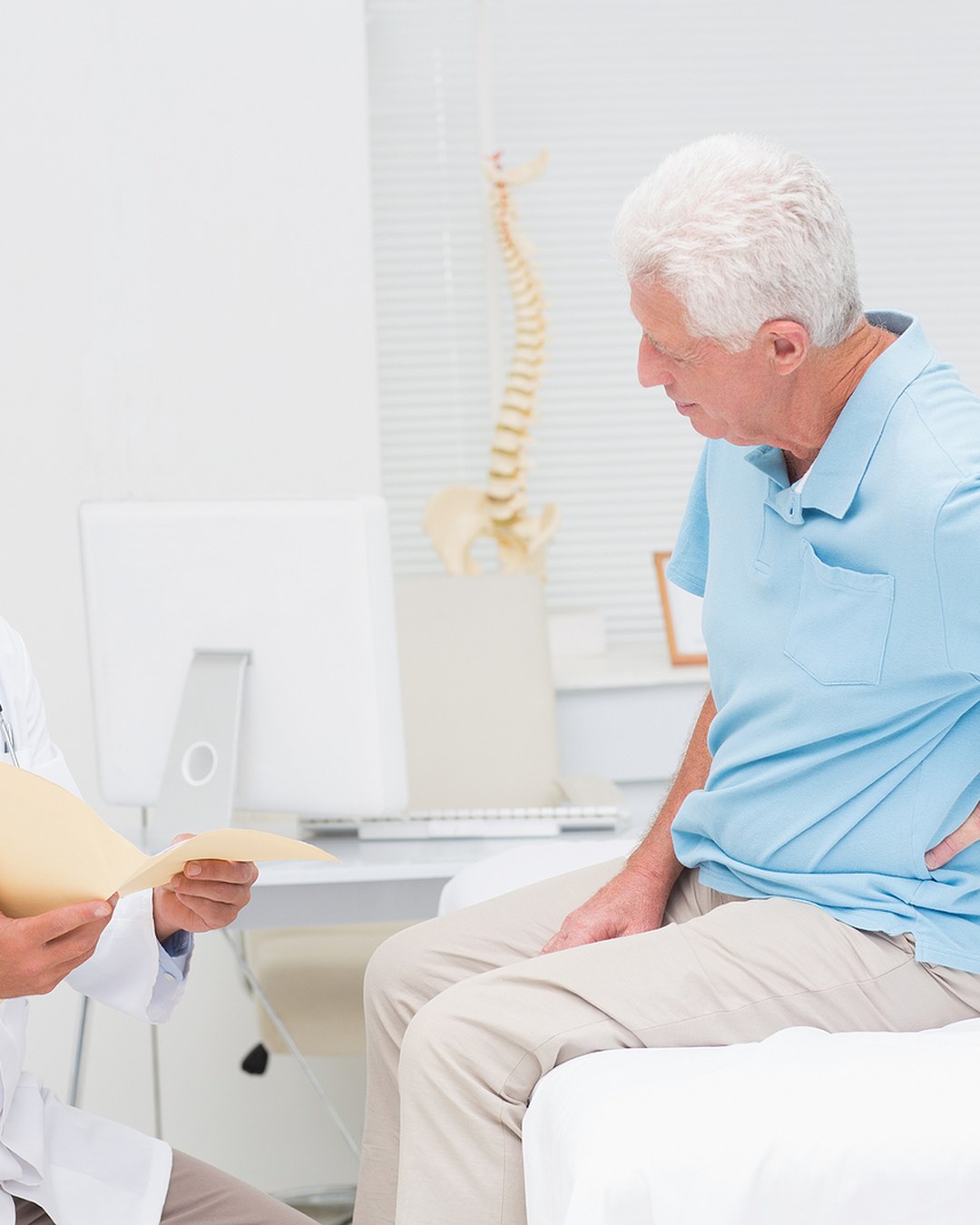 Sciatica Auckland 2 Practitioner discussing back pain with an older patient in the clinic