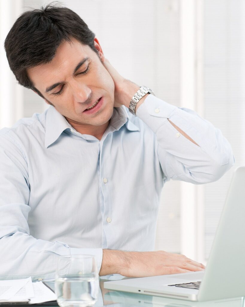 Neck Pain North Shore 1 Neck Pain North Shore — office worker at a laptop holding a painful neck