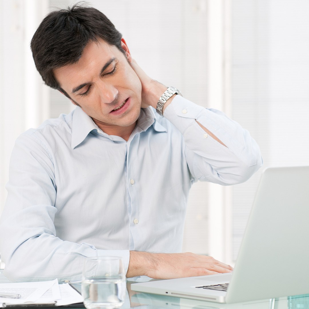 TMJ & Jaw Pain Auckland 2 Office worker at a laptop holding a stiff neck