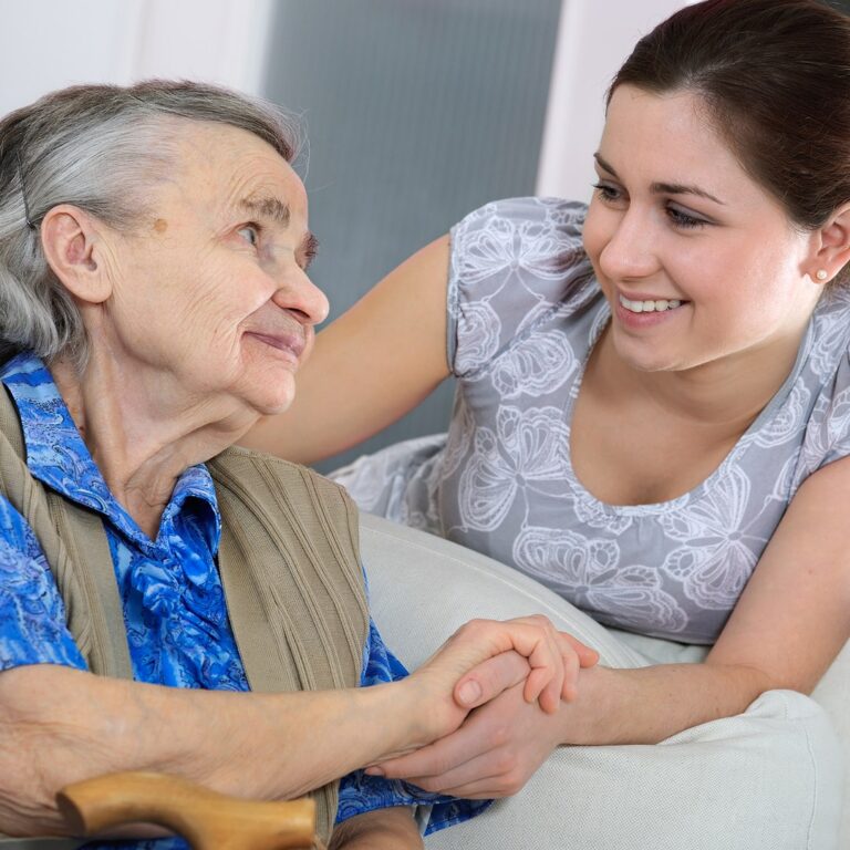 Younger woman holding an older woman’s hand