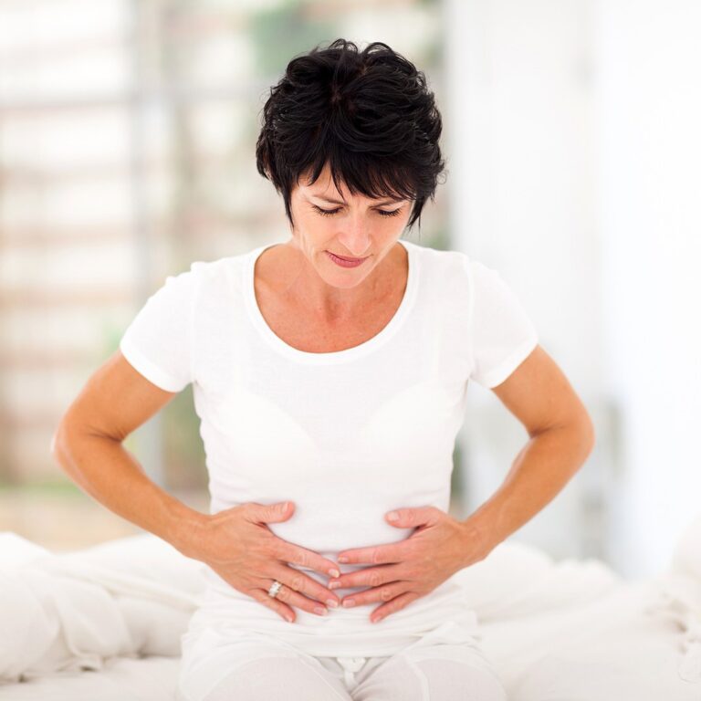 Woman holding her abdomen with gut pain