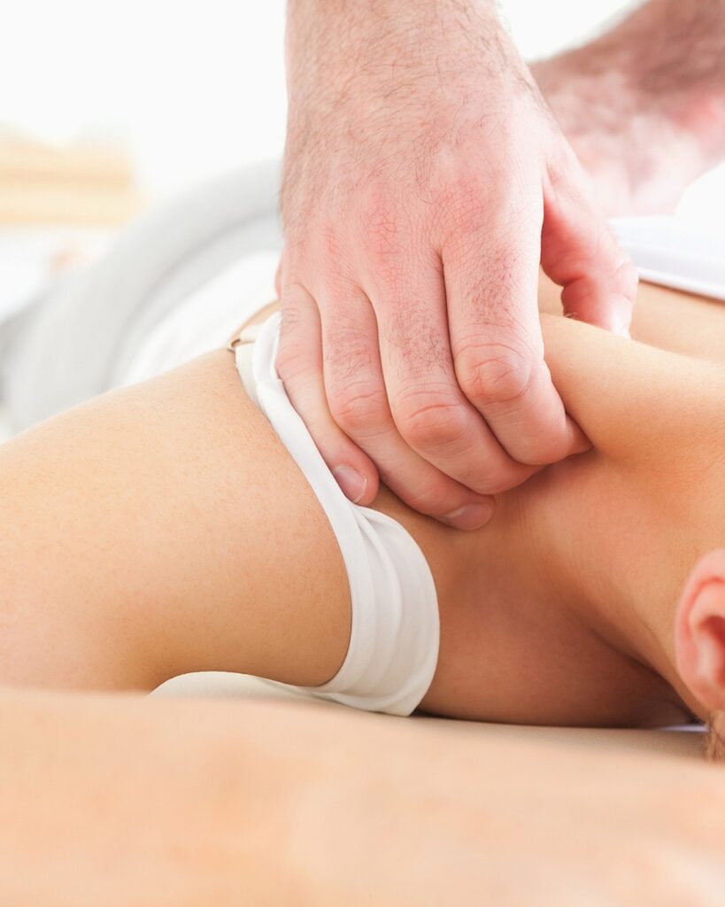 Massage therapist easing tension through the neck and shoulders