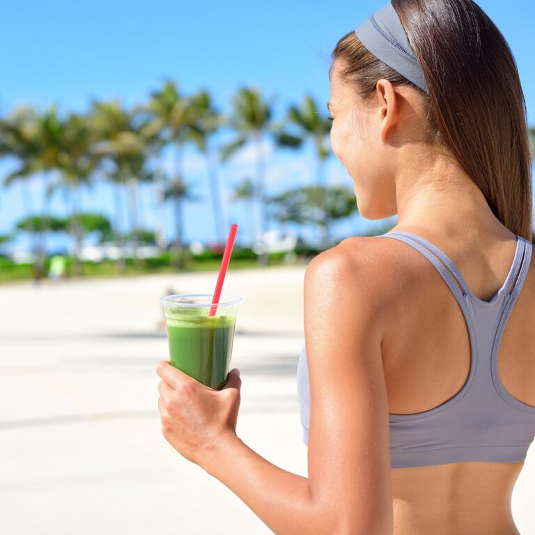 Woman outdoors holding a green vegetable smoothie