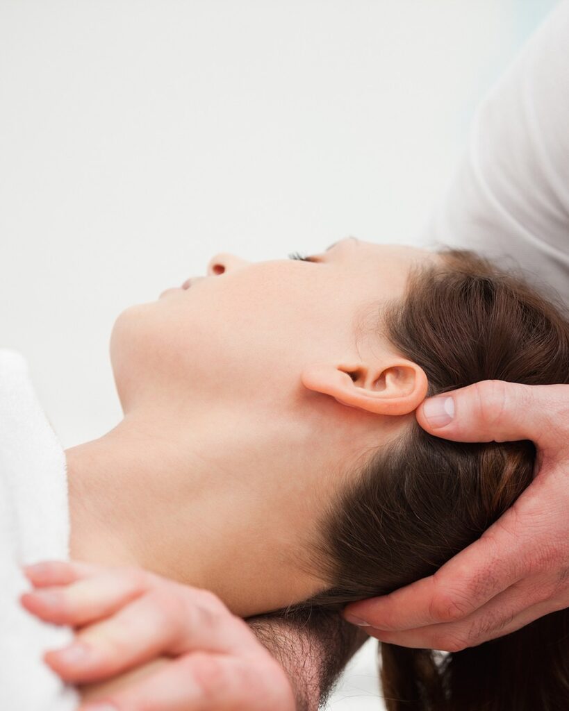 Osteopath Orewa 2 Osteopath supporting a patient's head and neck during a gentle cervical technique