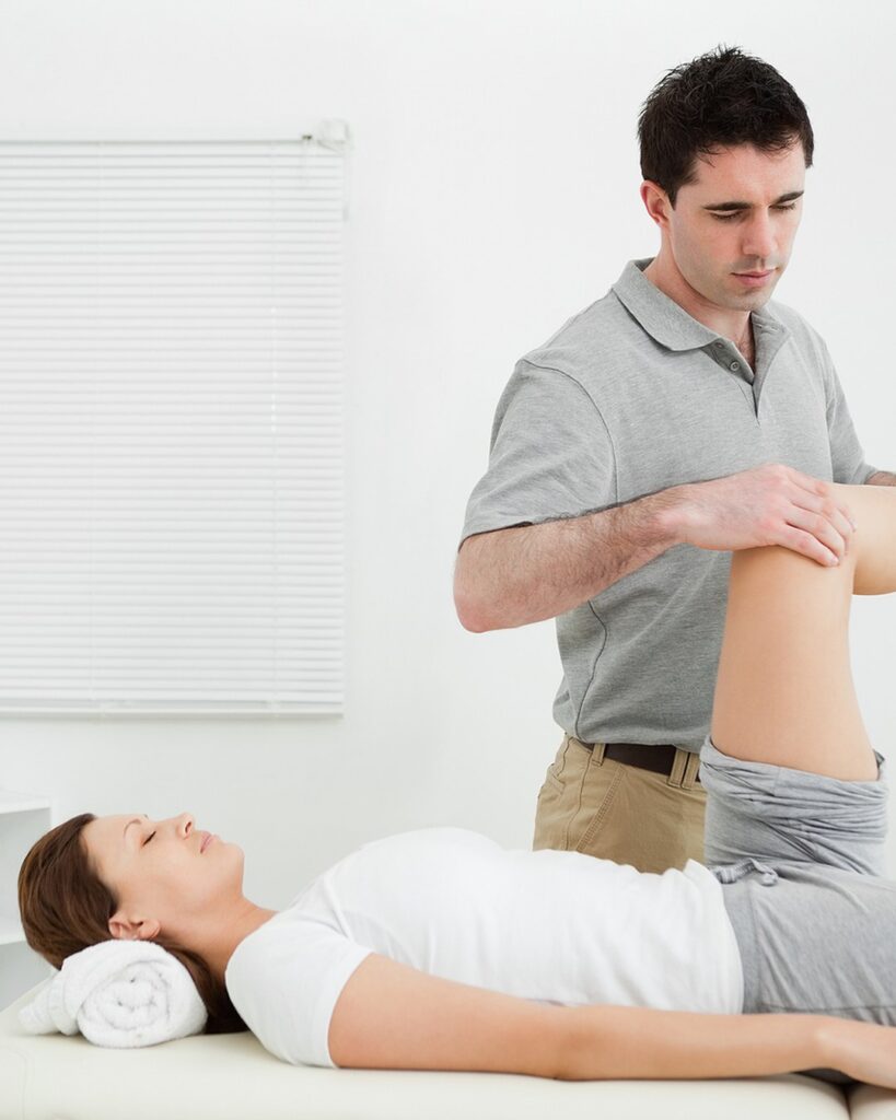 Joint Pain North Shore 3 Physiotherapist bending a patient’s knee while she lies on her back